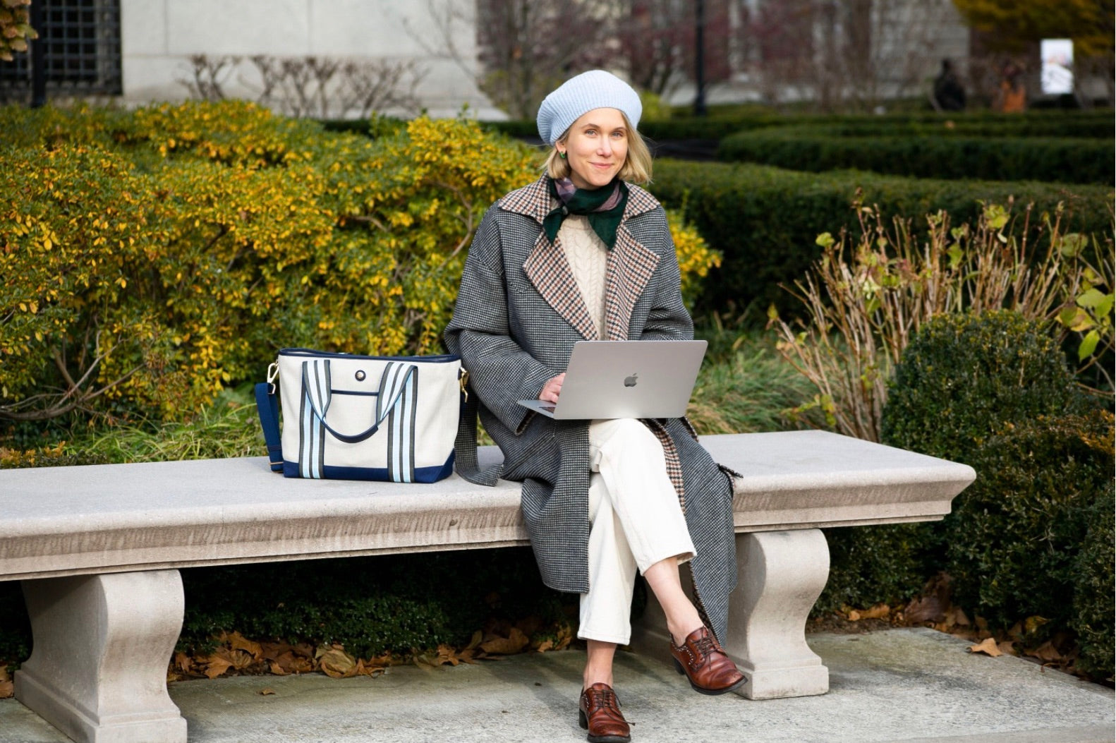 Indre Rockefeller on an outside bench with her laptop